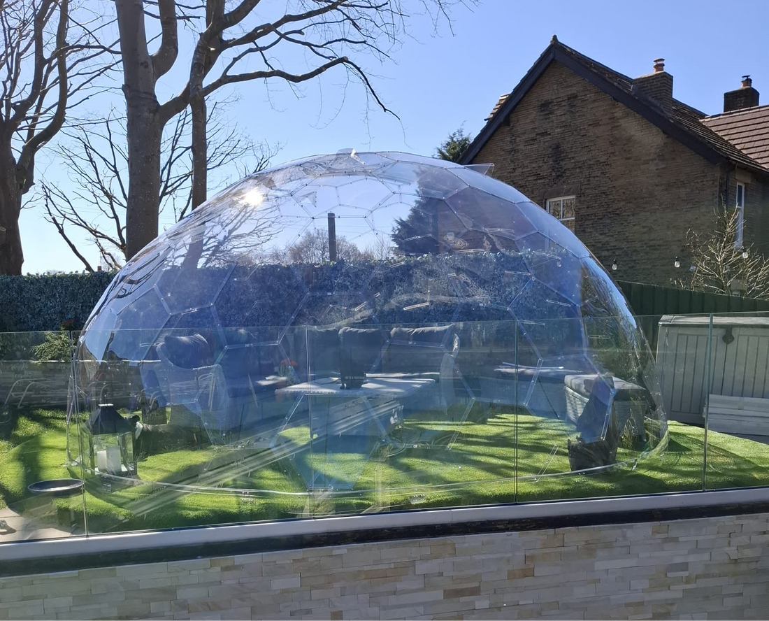 A GeoDomeX dome in a back garden beside a brick house