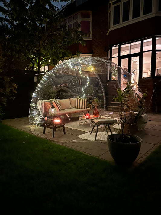 A cosy GeoDomeX lounge lit by lanterns at night